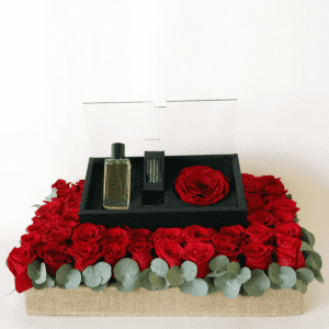 revealing red perfume arranged on filling with red roses and eucalyptus