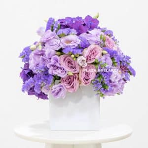 Purple flower arrangement in a white pot