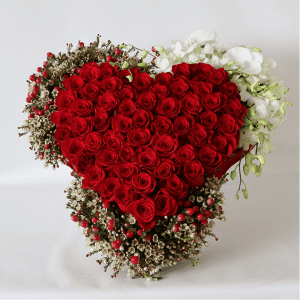 large red rose heart surrounded by hypericum, wax flower and orchids