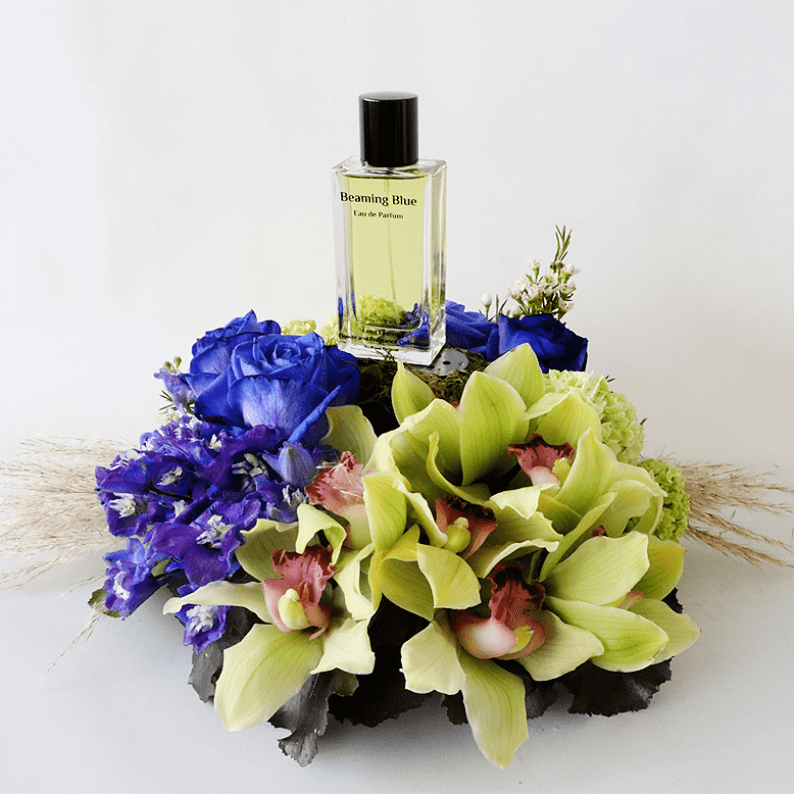 Cymbidium orchids with blue rose and delphinium in an arrangement with beaming blue perfume