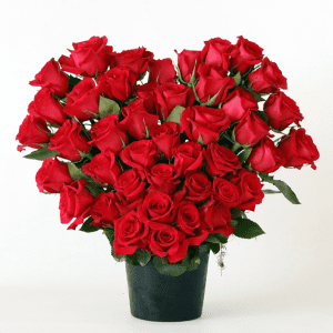 large red roses arranged in a heart shape in a black ceramic pot