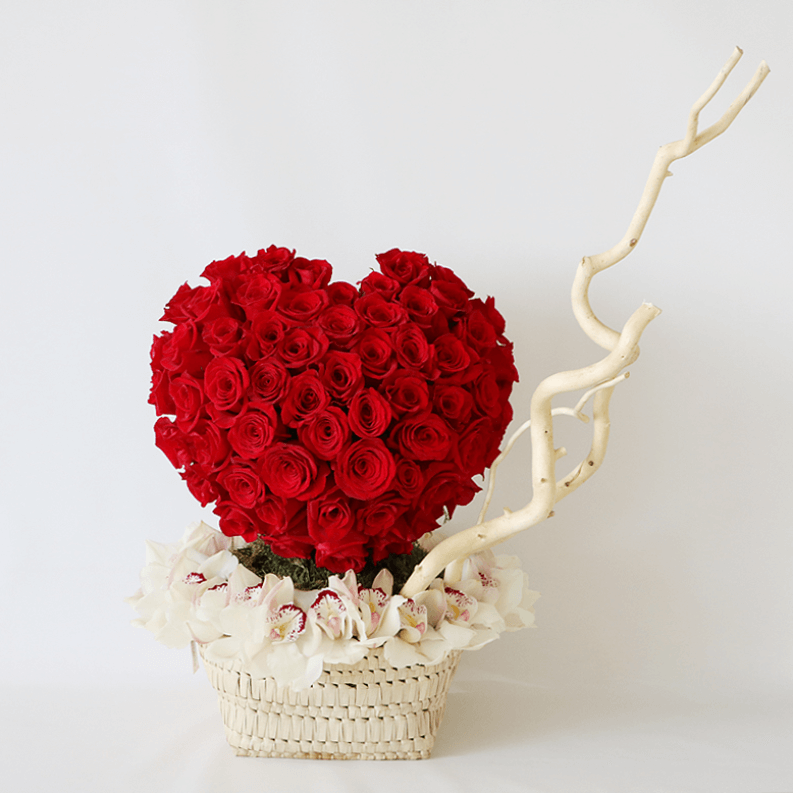 red rose heart surrounded by white cymbidium orchids and salex on a handmade basket
