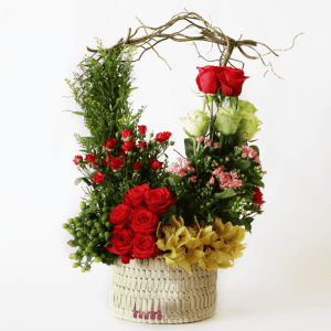 Red and green roses with spray roses, yellow cymbidium orchids in a basket