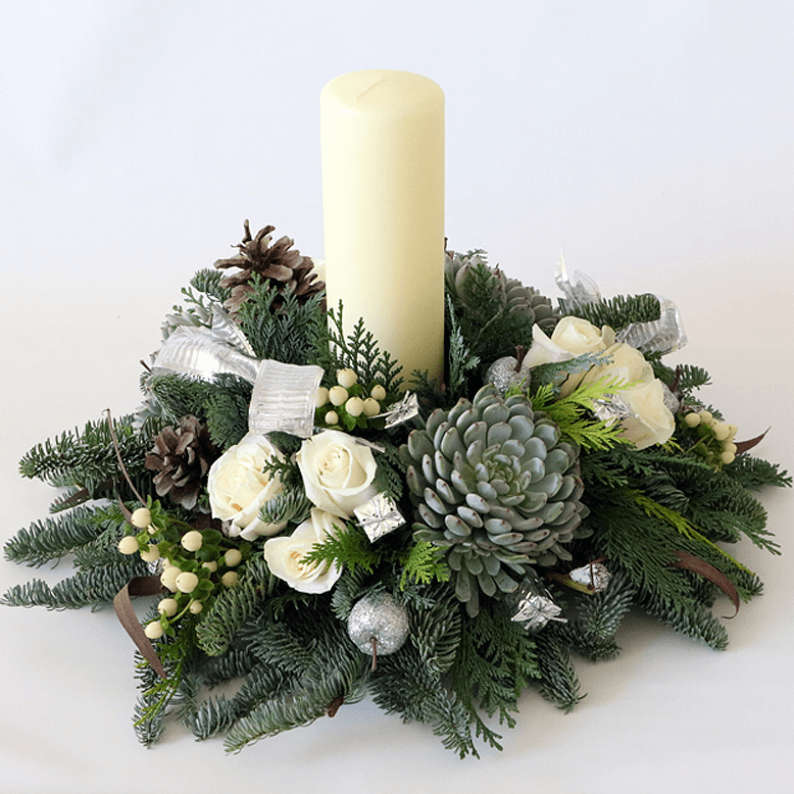 White candle and white roses with succulents and nordic spruce