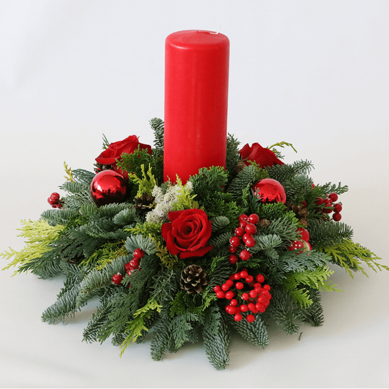 red candle and nordic spruce arrangement for christmas