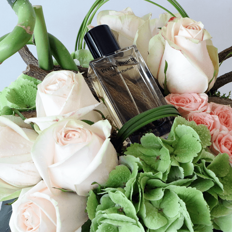 close up of pretty peach perfume with green hydrangea and peach roses