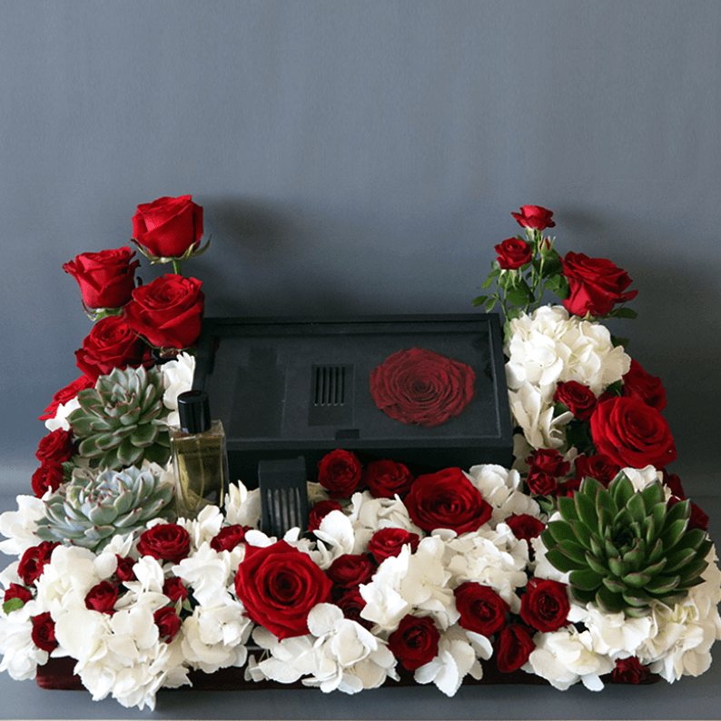 Box of revealing red perfume with oud and red roses and white hydrangea
