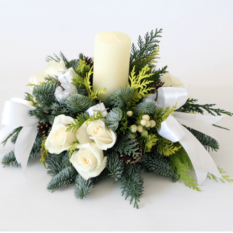 white pillar candle in spruce with white roses