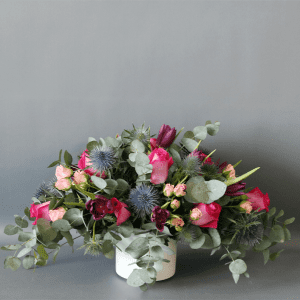 pink roses, purple tulips and eucalyptus in a white pot