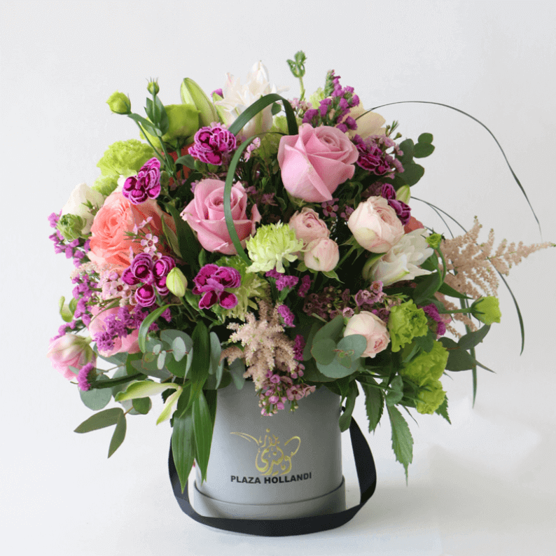 european design of purple roses, ranunculus, astilbe, carnations arranged in a plaza hollandi box