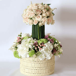 Spray rose, astilbe on a steal grass podium on white hydrangea, hypericum and snowball in a basket