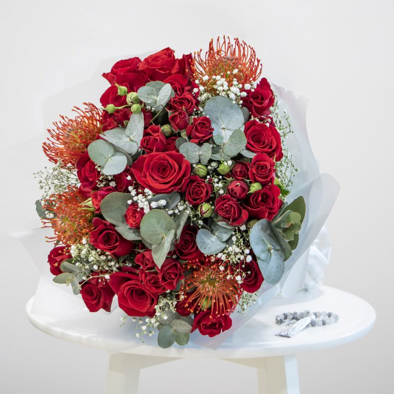 red and green bouquet with grey prayer beads