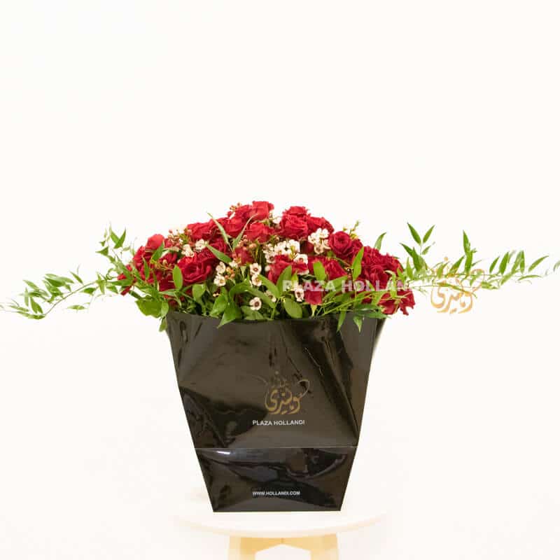 A black Plaza Hollandi bag with red spray roses and wax flower
