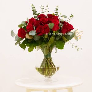 50 red roses with eucalyptus in a vase