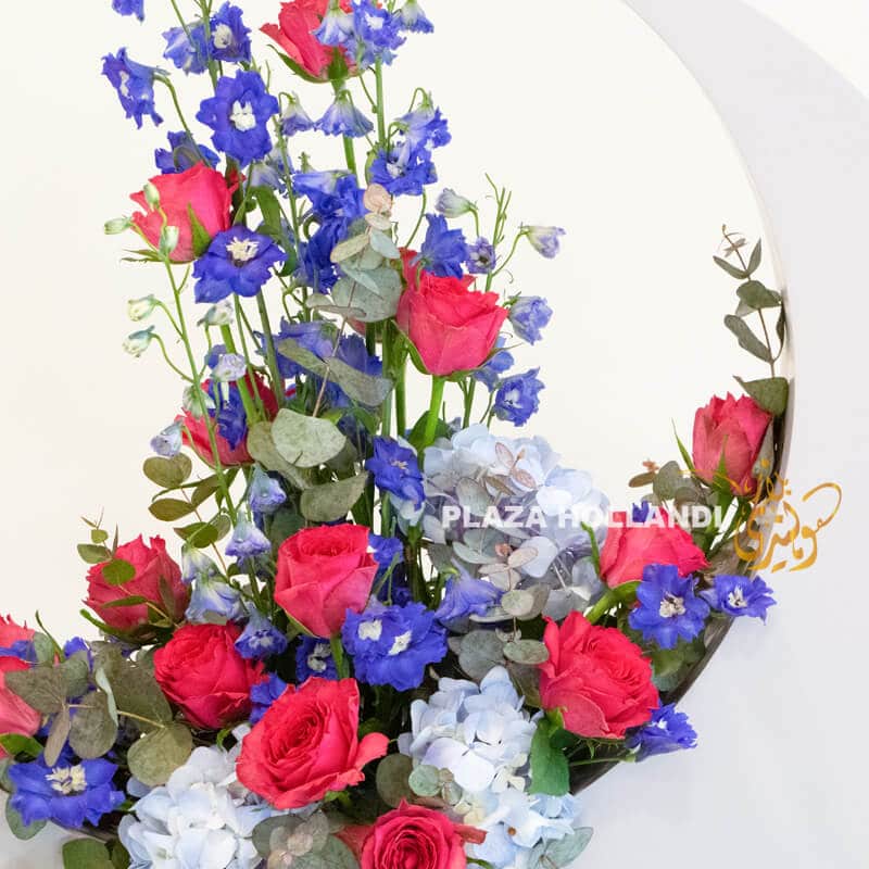Roses, delphinium and hydrangea in a crescent moon