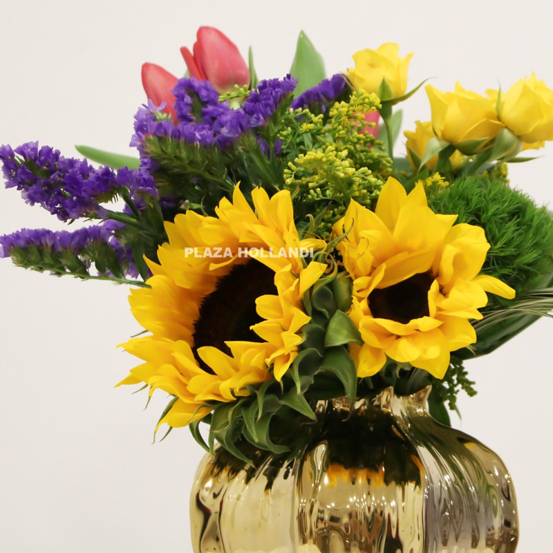 close up of sunflower arrangement in gold pot