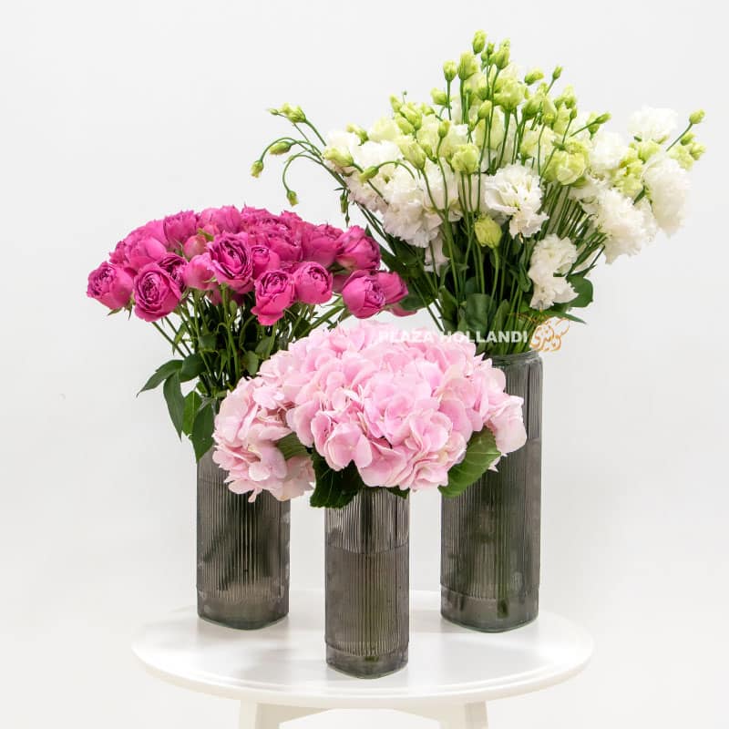 three glass vases filled with flowers