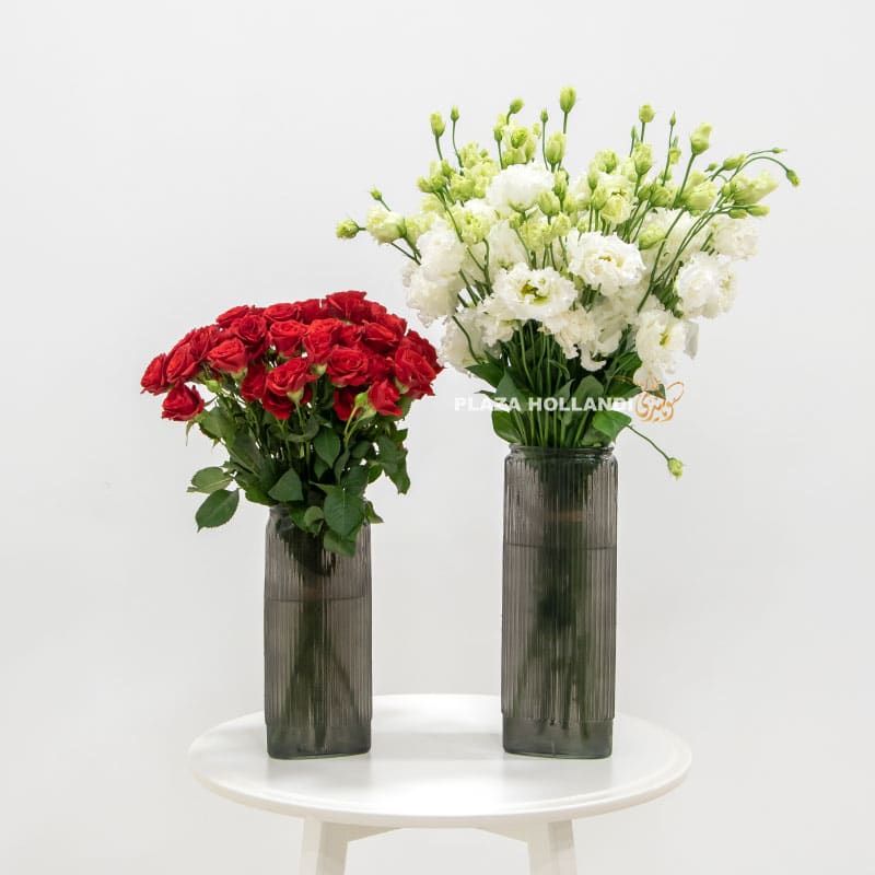 two vases filled with red roses and white eustoma