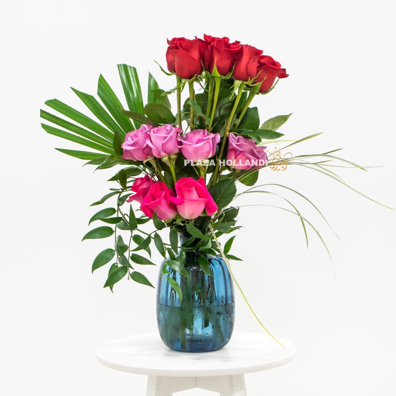 red, purple and pink roses in a blue vase