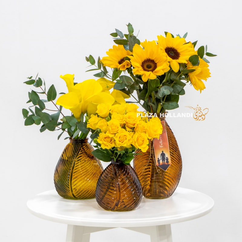 Three vases filled with yellow flowers