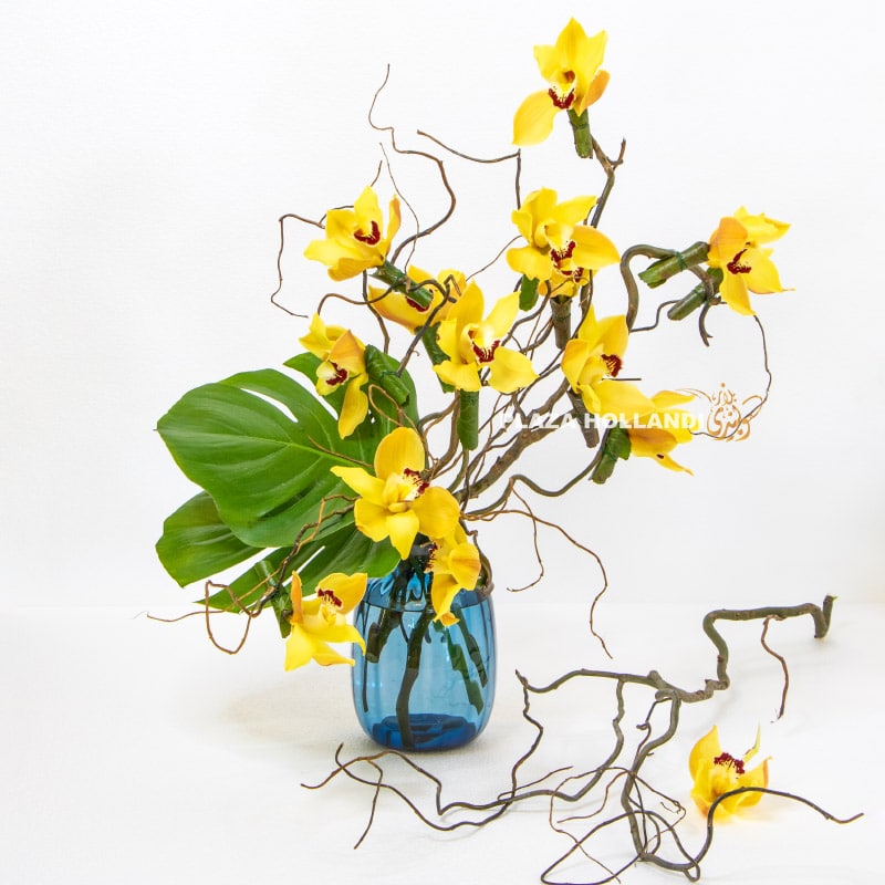 Yellow cymbidium Orchid flower design in a blue vase