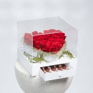 a white box of roses and chocolate